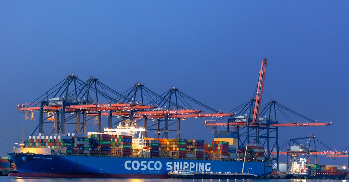 Containerschip Meert Aan In De Haven Tijdens De Schemering, Met Kranen Op De Achtergrond